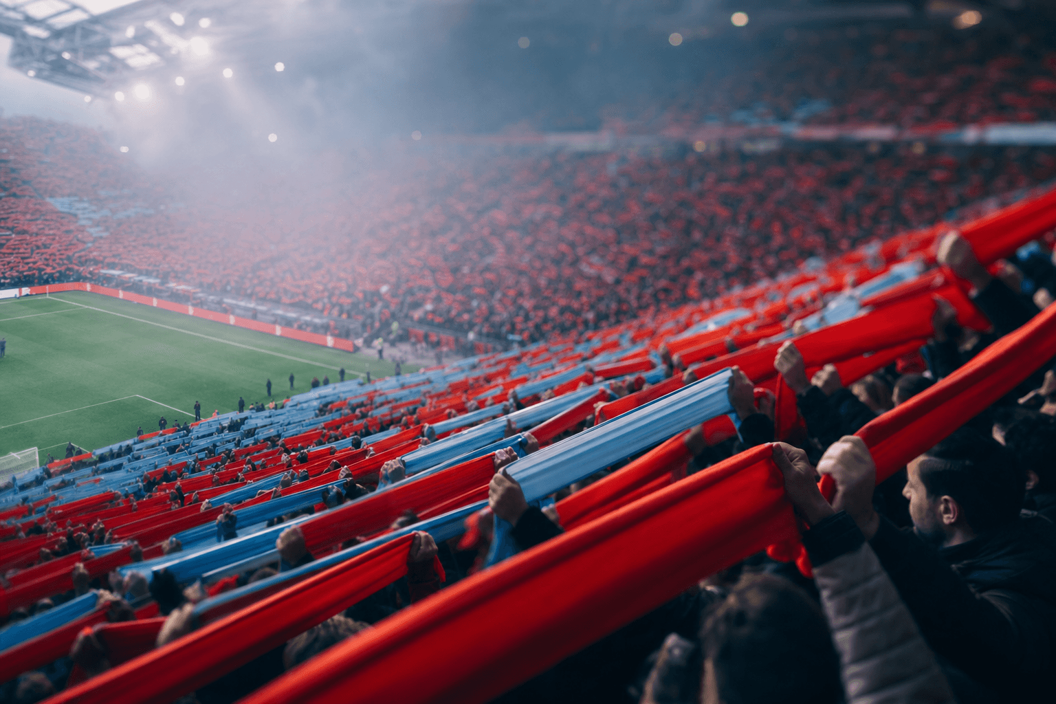 Tilt-shift view of a packed stadium tribune at a derby moment